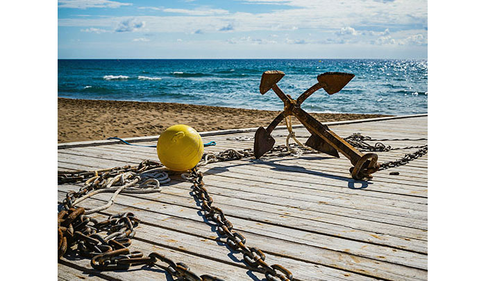 ancre et sa chaîne sur un ponton au bord de la mer